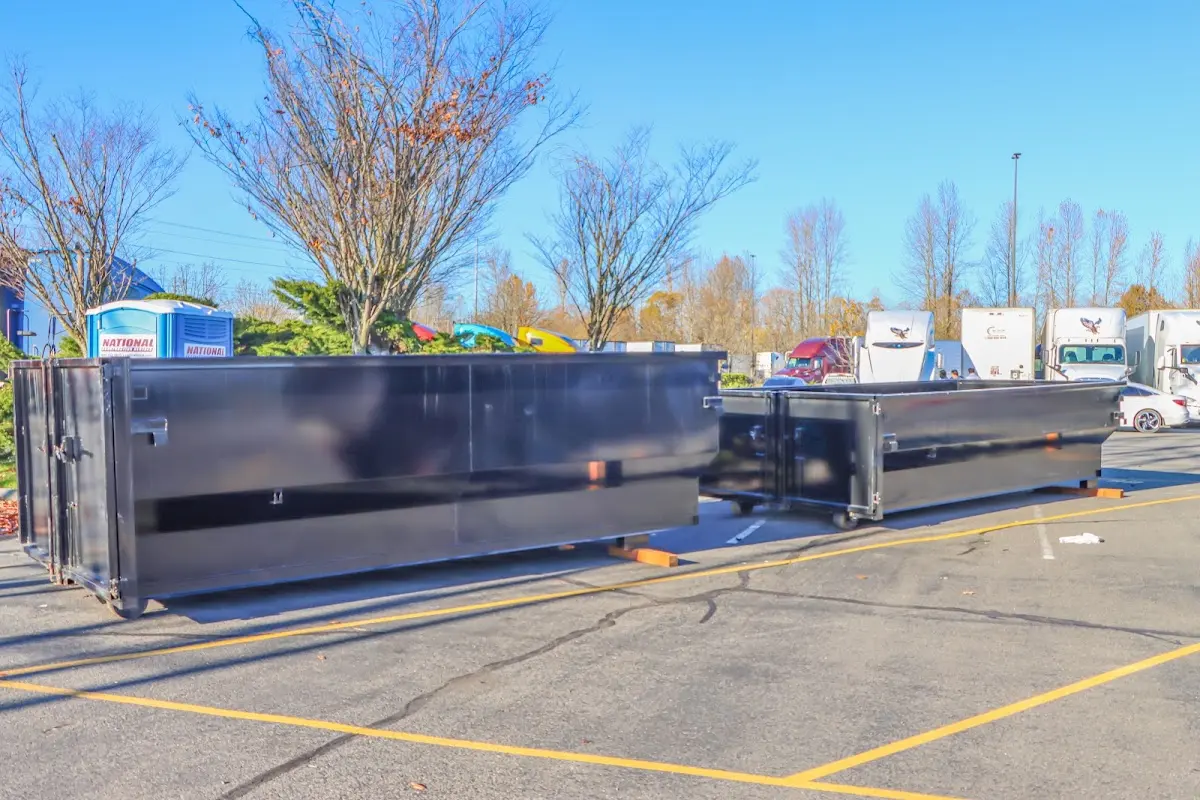 Professional dumpster rental service with roll-off container on residential driveway in Henderson